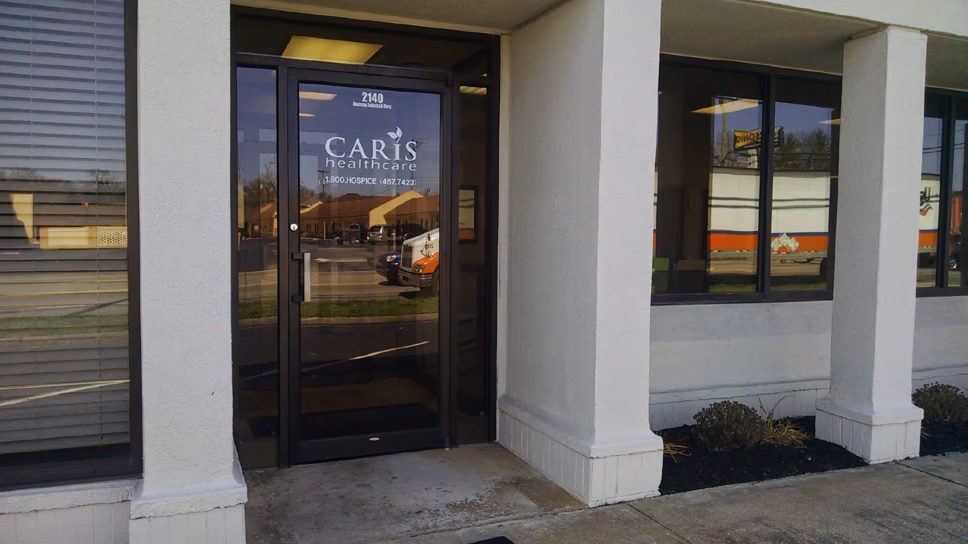 Exterior view of Caris Healthcare entrance with glass doors and columns