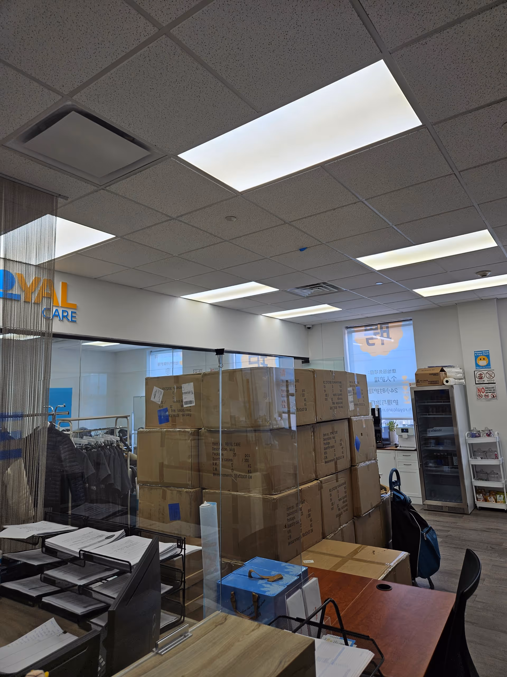 Office area inside Royal Care with stacked cardboard boxes, desks, and filing materials.