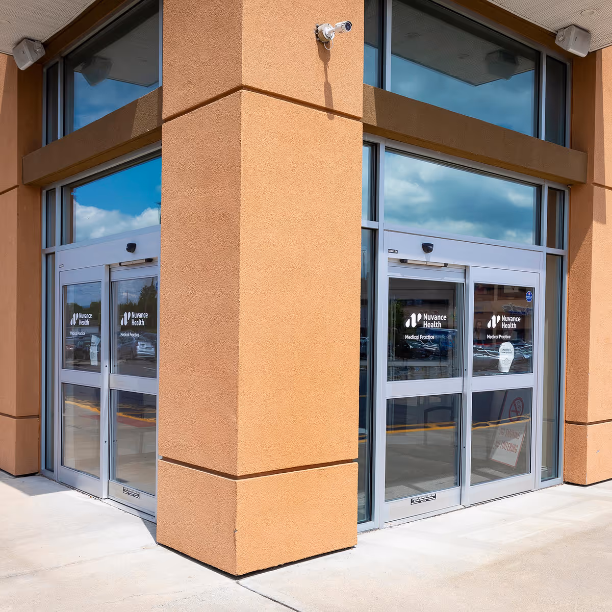 Exterior corner of a beige building with glass doors labeled Nuvance Health Medical Practice Kingston.