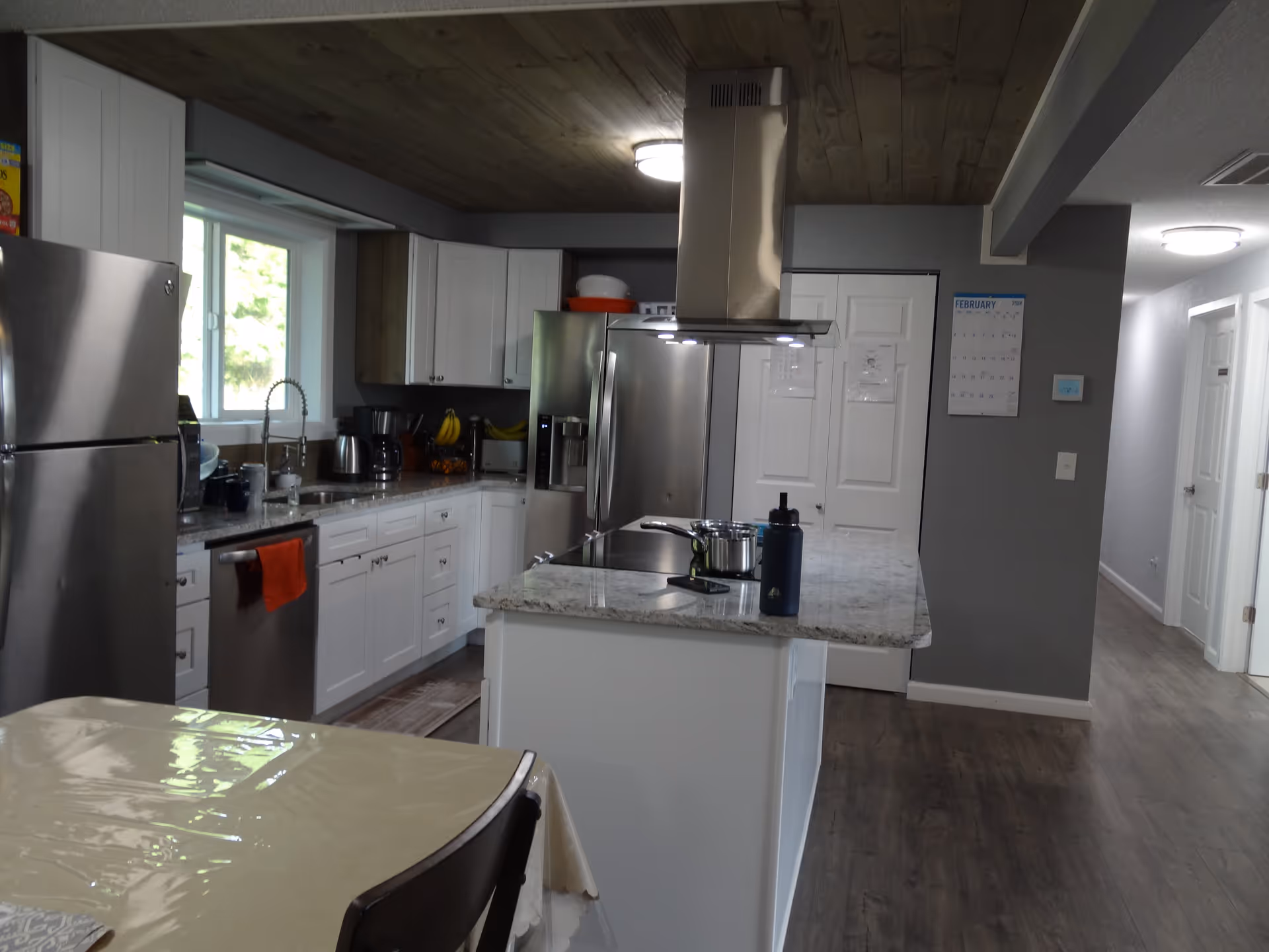 Bright modern kitchen in a senior living home with white cabinets, stainless appliances, and an island.