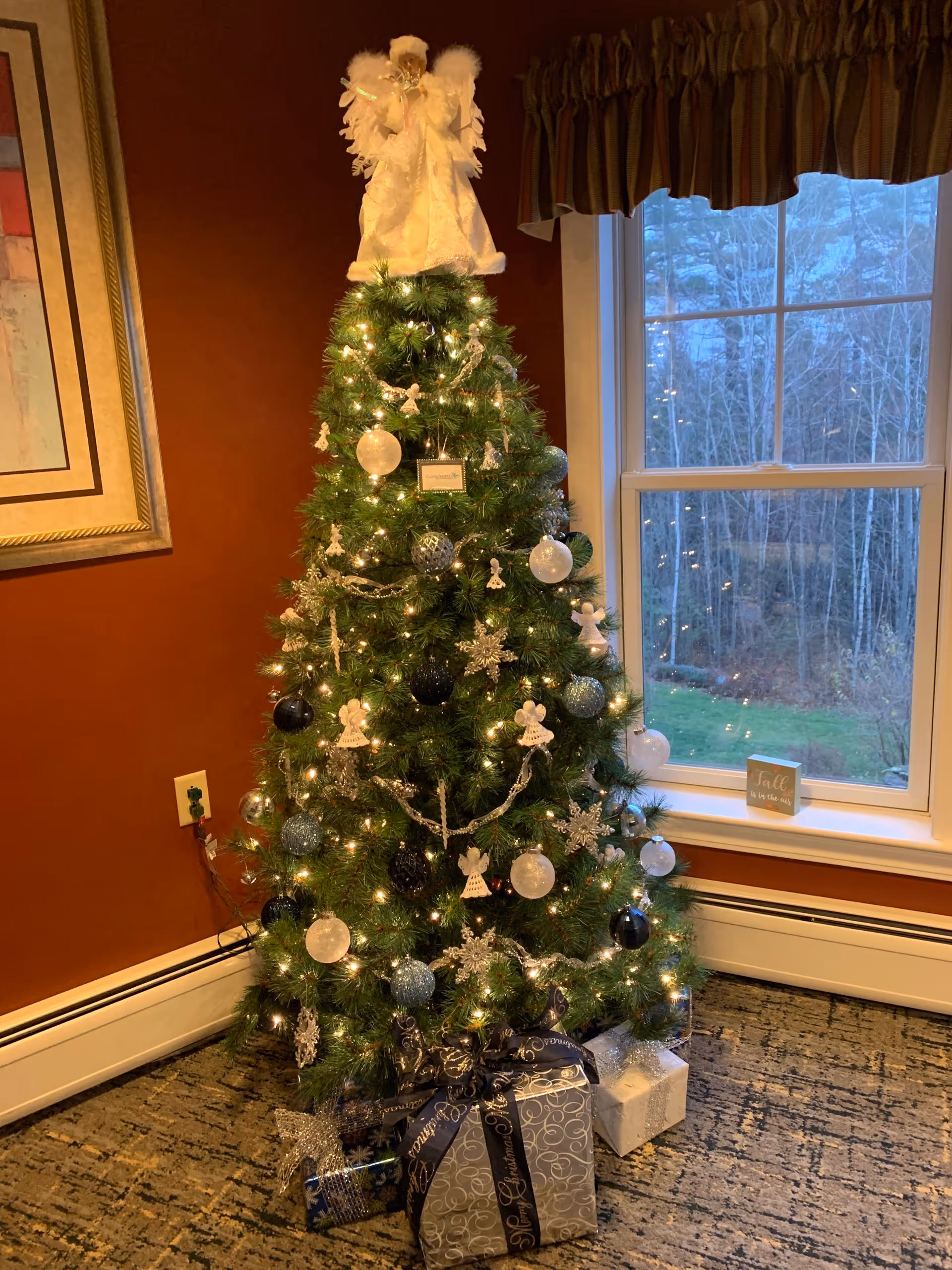 Cozy interior scene with a decorated Christmas tree, lights, and gifts.