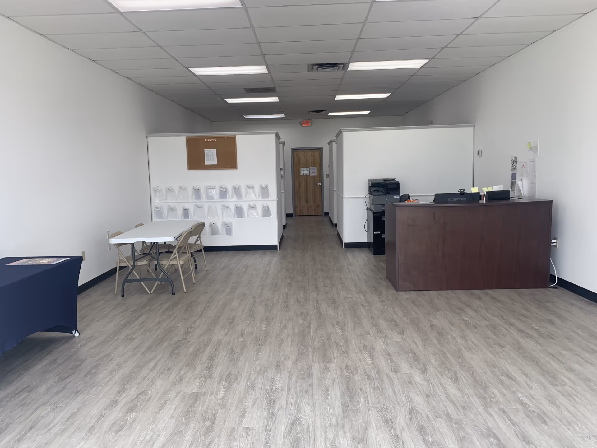 Office-like reception area inside a senior care facility, with a dark desk and cubicles.