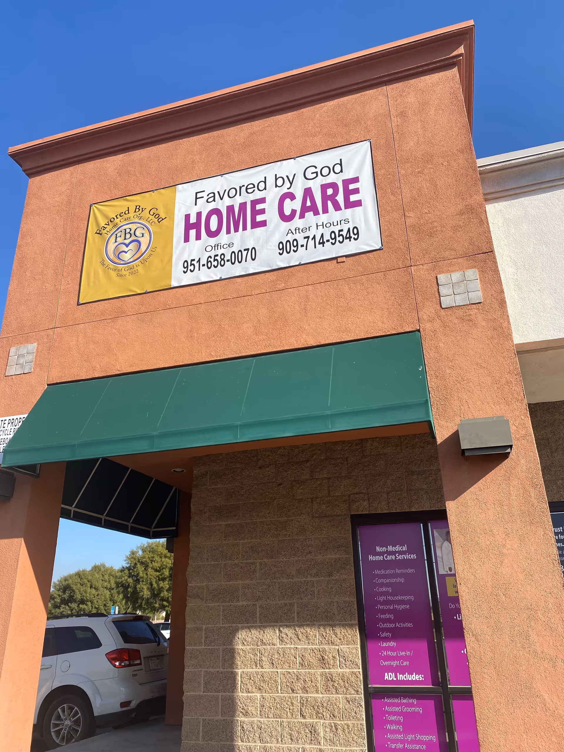 Orange stucco building front with a large banner for Favored by God Home Care.