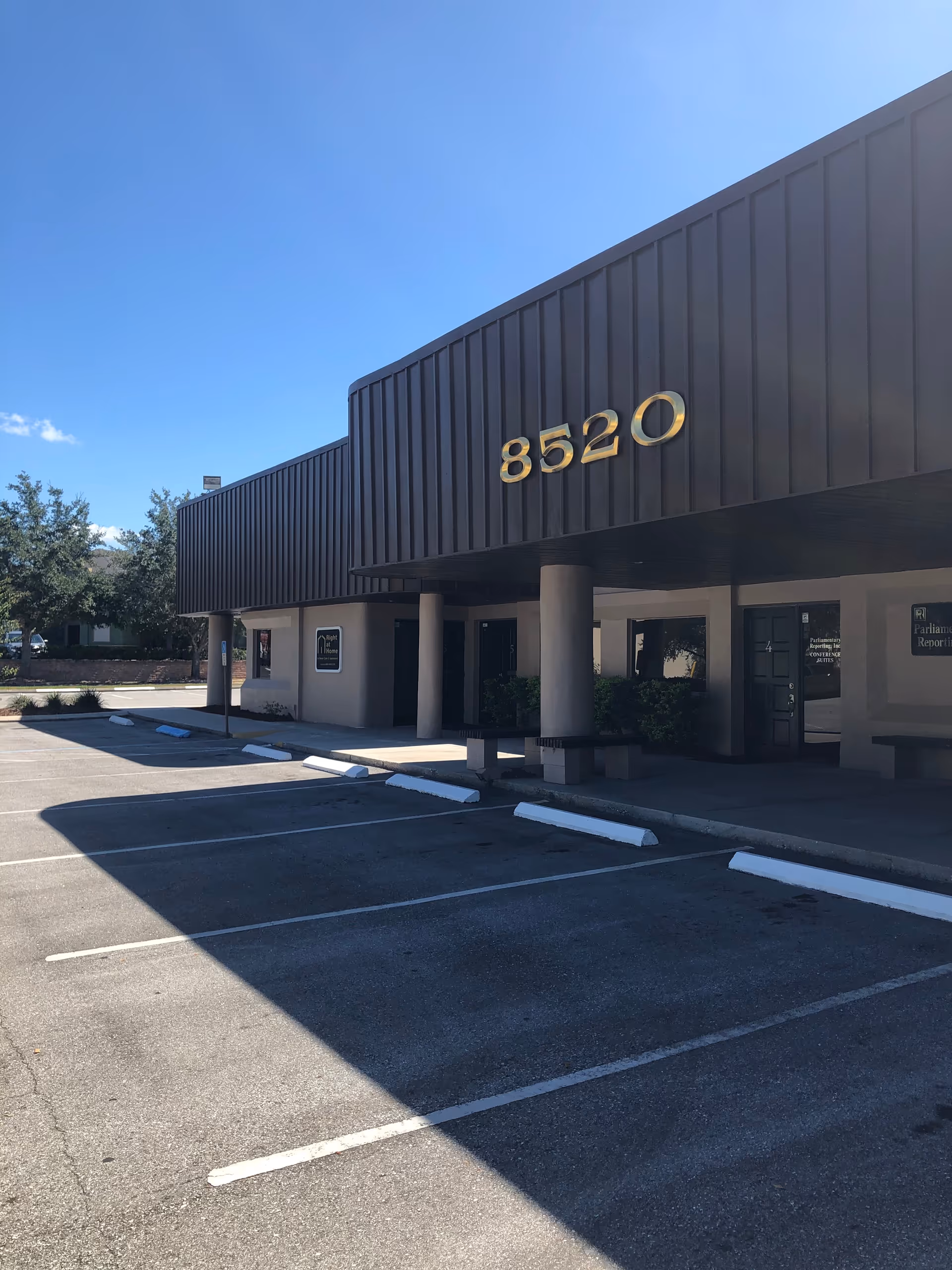 Exterior view of a Right at Home facility entrance with large 8520 numbers and parking.