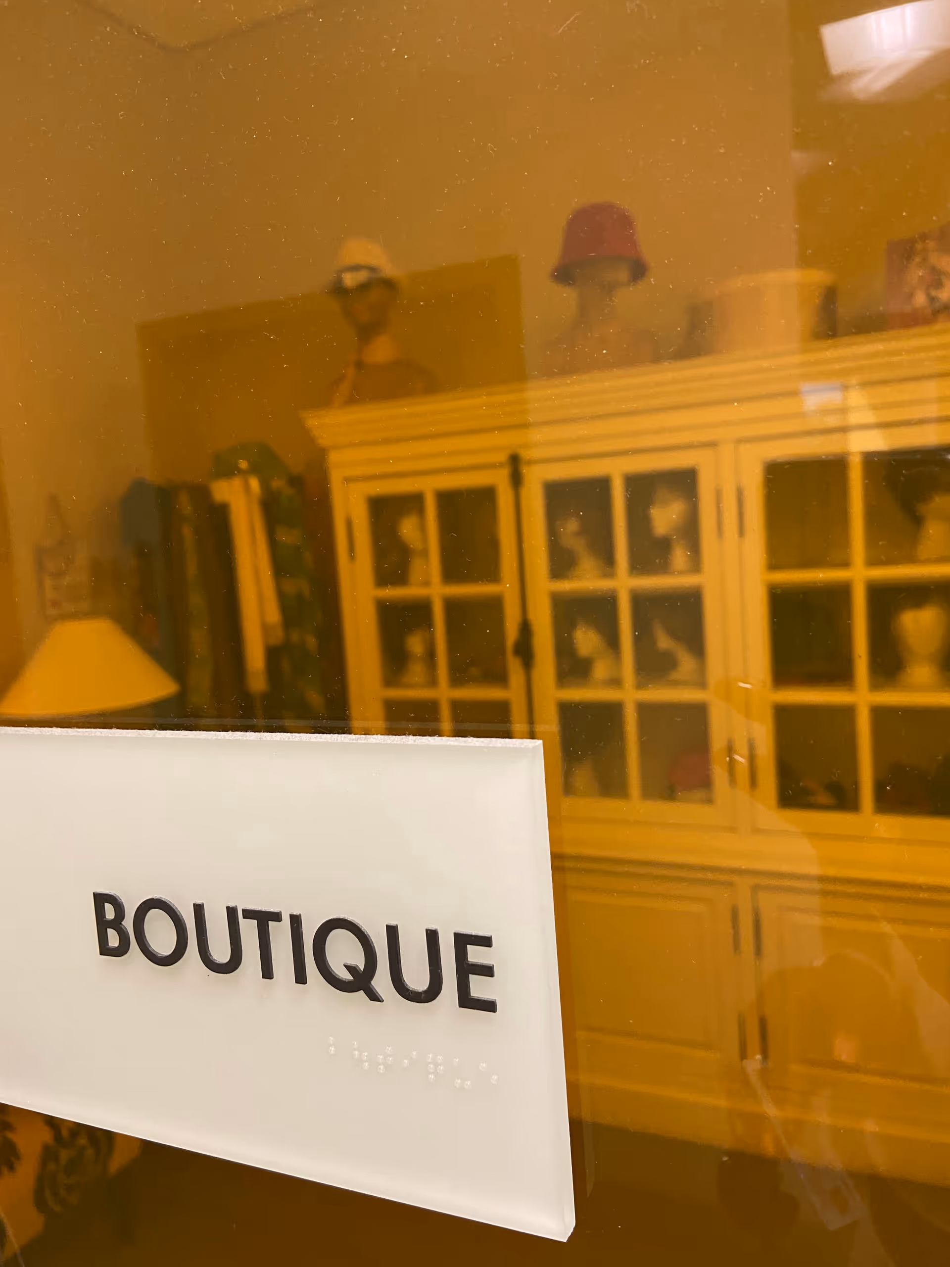 Shopfront boutique interior with a prominent 'BOUTIQUE' sign and display cabinets.