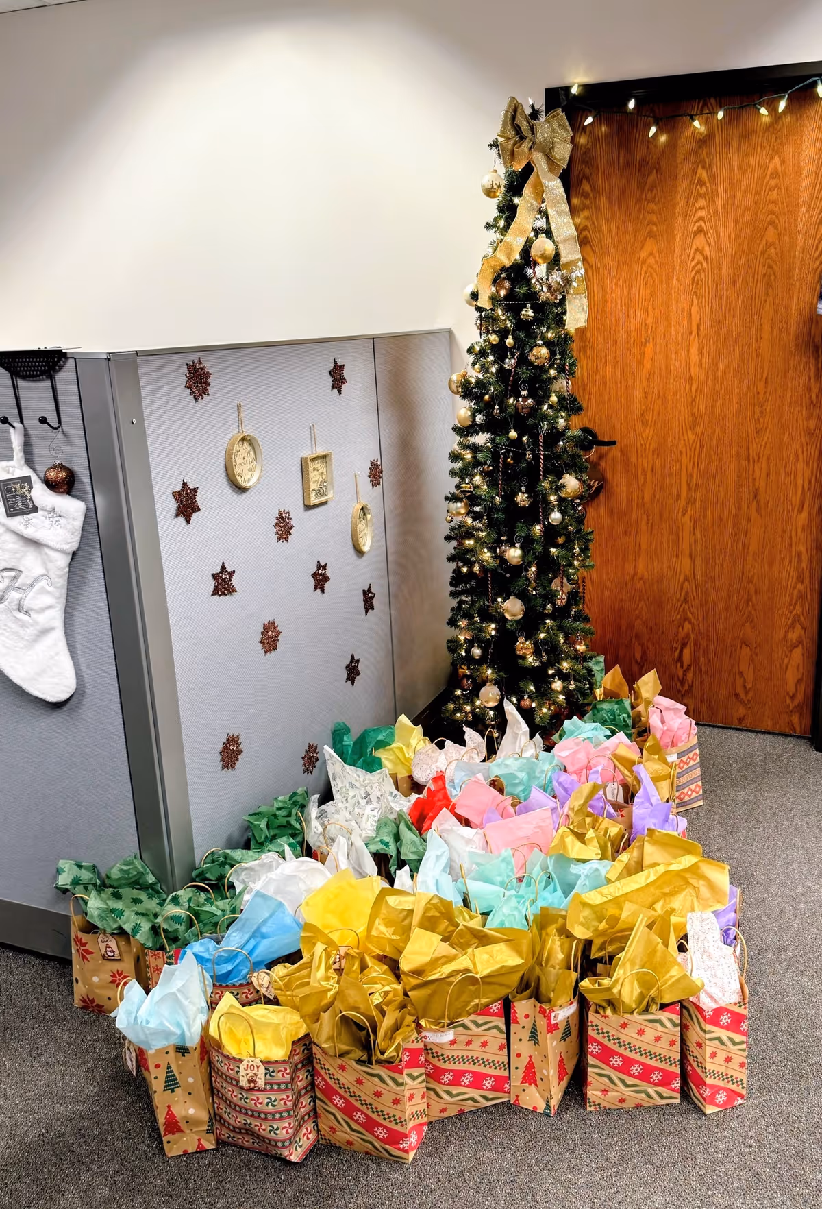 Festive hallway in senior home care with Christmas tree and colorful gift bags.