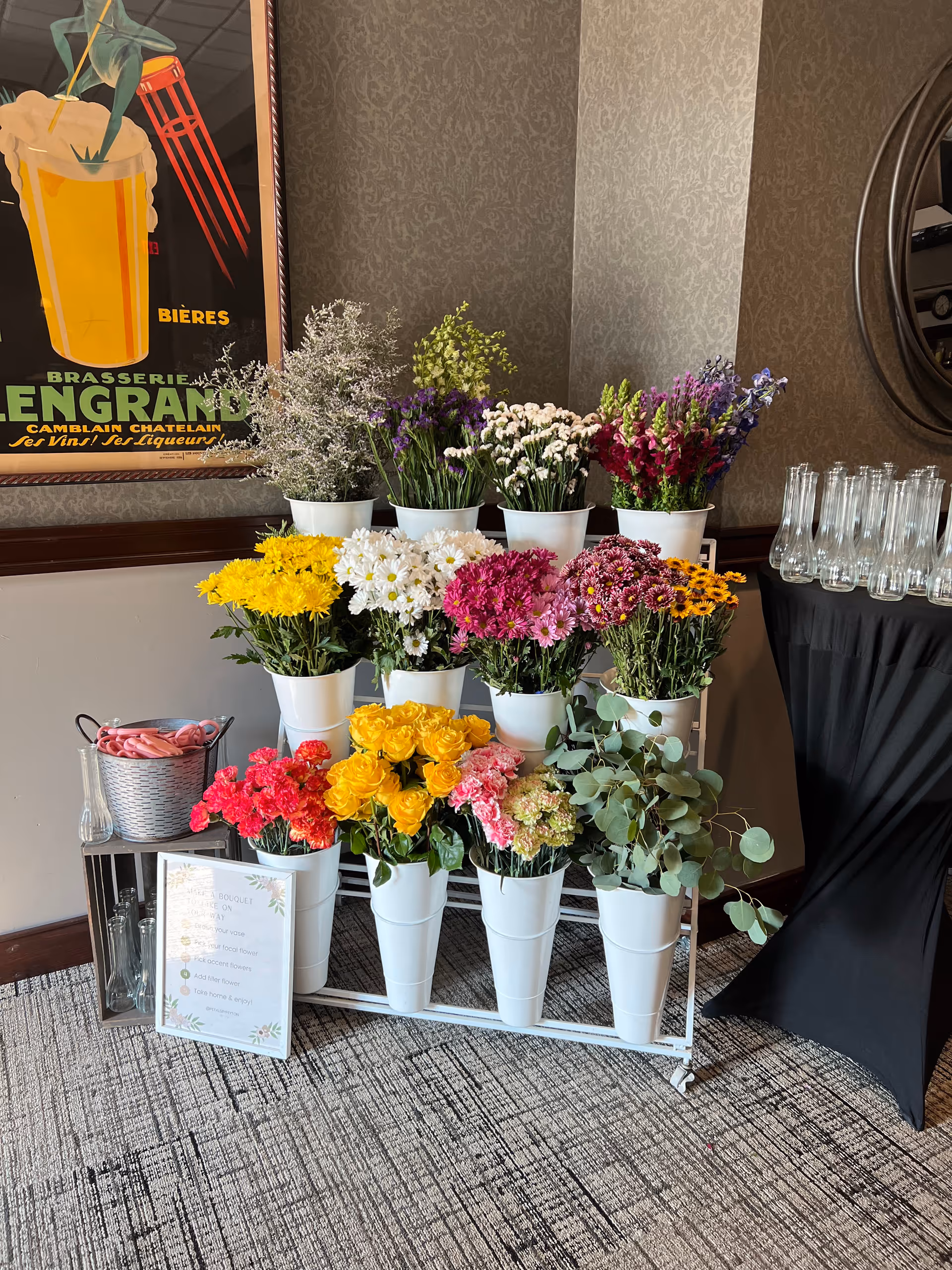 Indoor facility lobby with colorful flower arrangements in white pots and glassware.