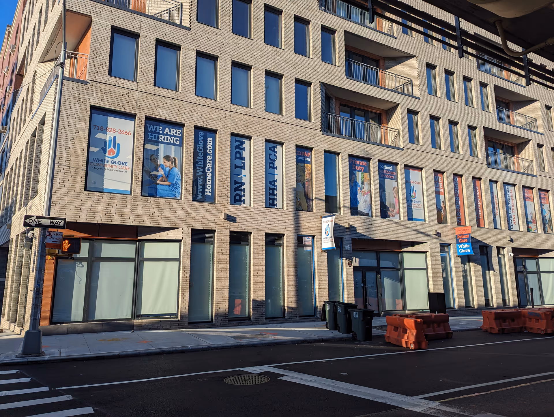 Brick building facade with banners along a city street.