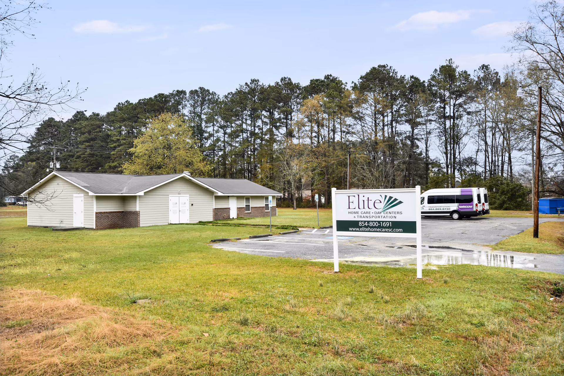 A single-story building complex with a front sign reading Elite Home Care and Day Centers, outdoors.
