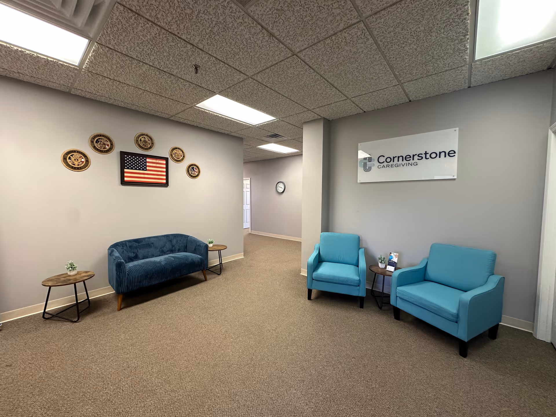 A Cornerstone Caregiving lobby with blue seating and patriotic wall decor.