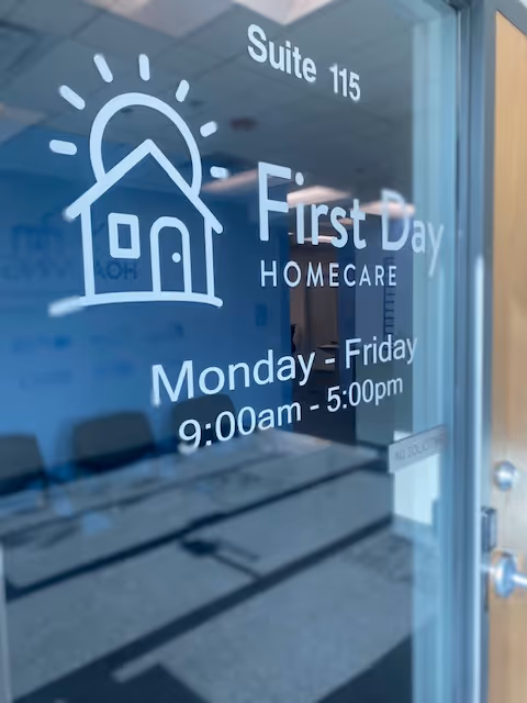 Glass door displays First Day Homecare signage; office lobby visible behind through glass.