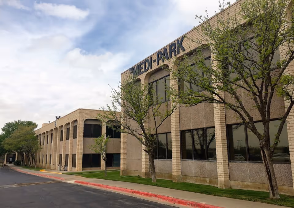 Exterior view of a brick medical building labeled Medi-Park with trees