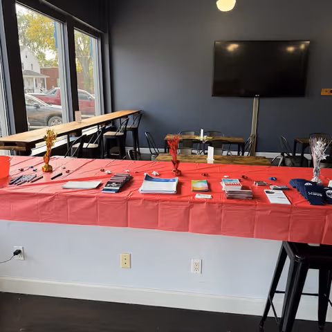 An interior room with a long red table showcasing brochures and promotional materials.