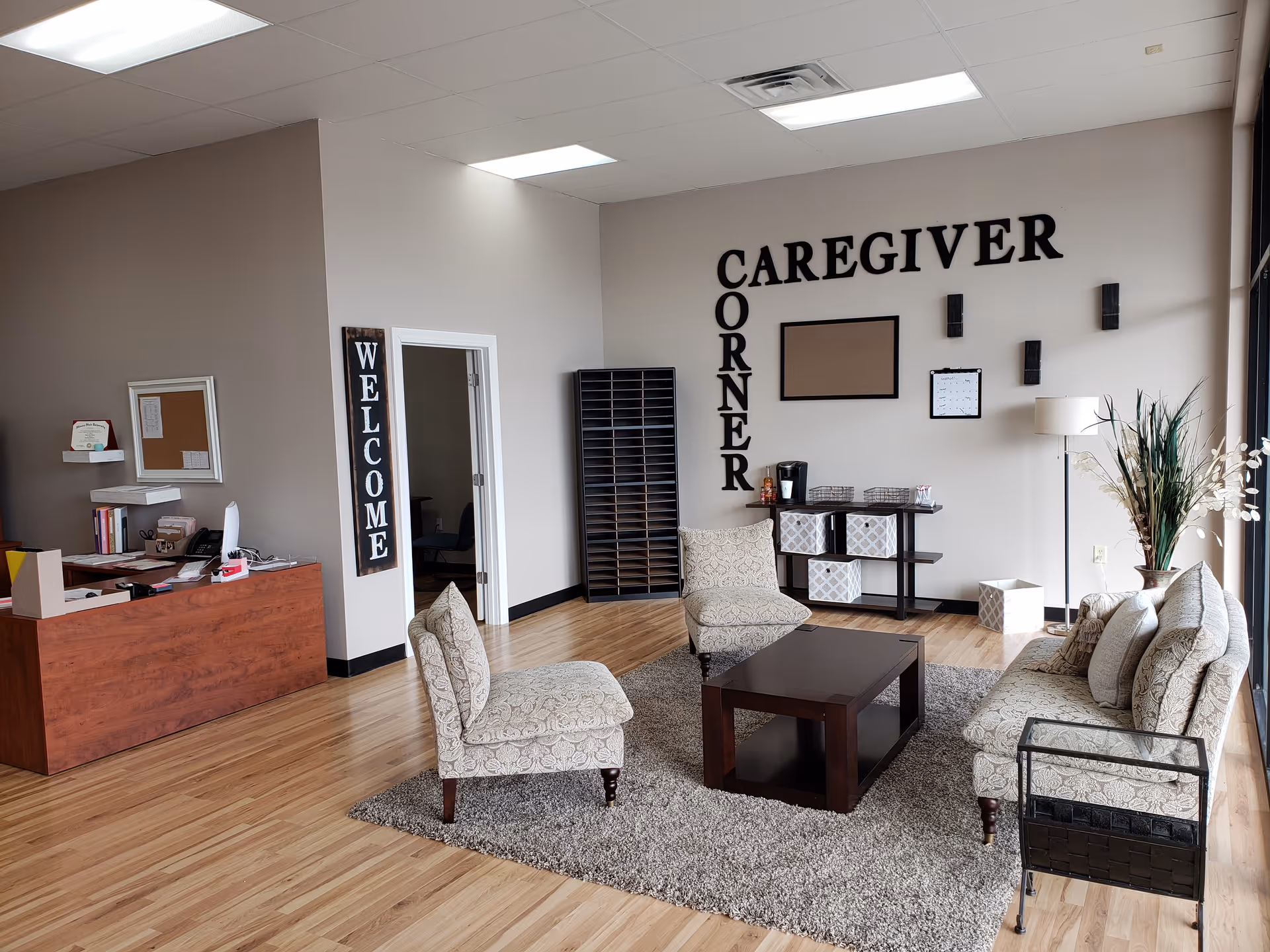Senior living facility lobby with seating, welcome signs, and a front desk area.