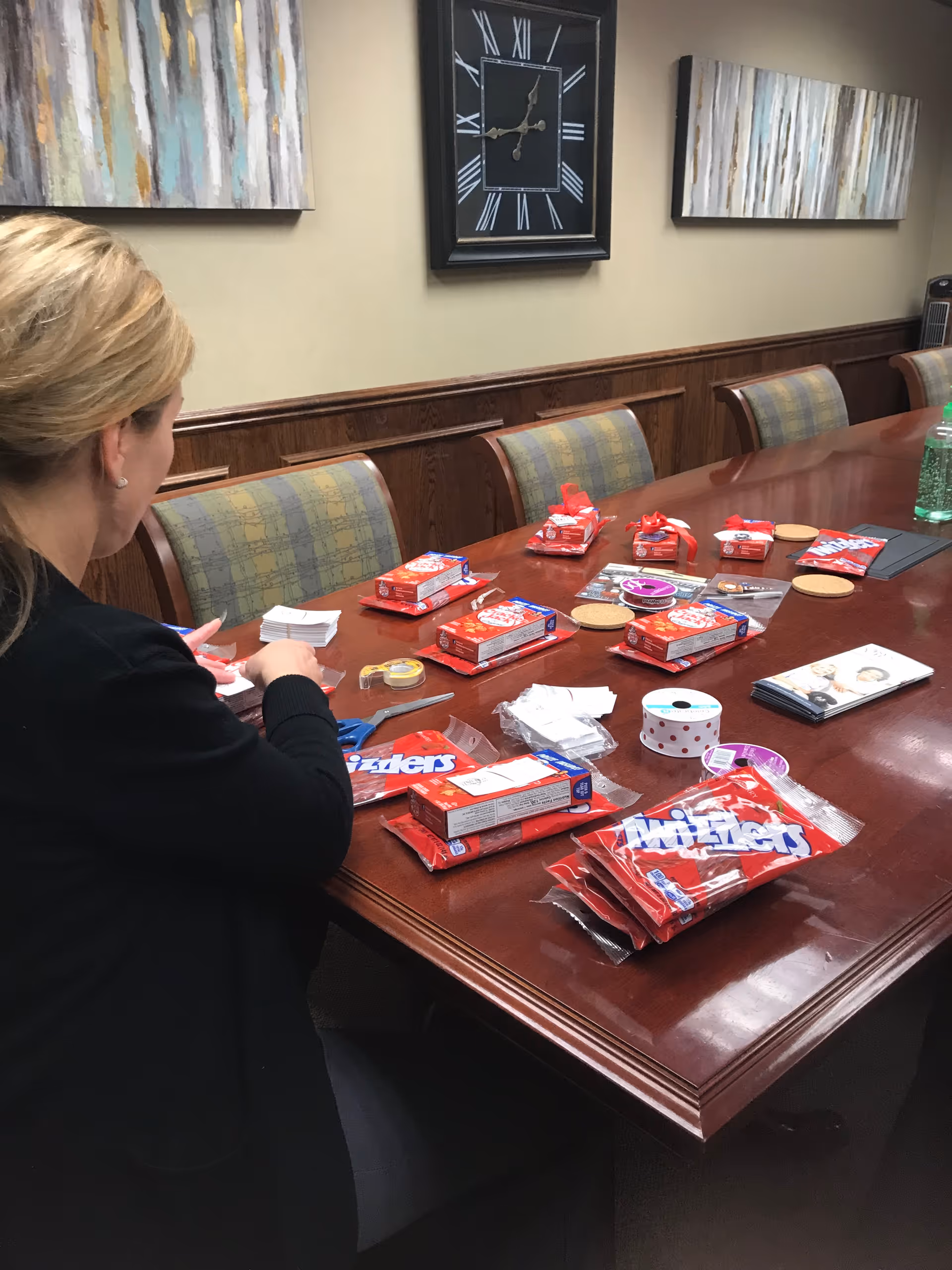 Caregiver seated at a large conference table filled with candy wrappers and craft supplies.