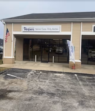 Exterior view of Senior Helpers facility with glass entrance doors and American flag.