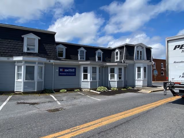 Exterior view of a HomeWell Care Services building with a parked delivery truck.