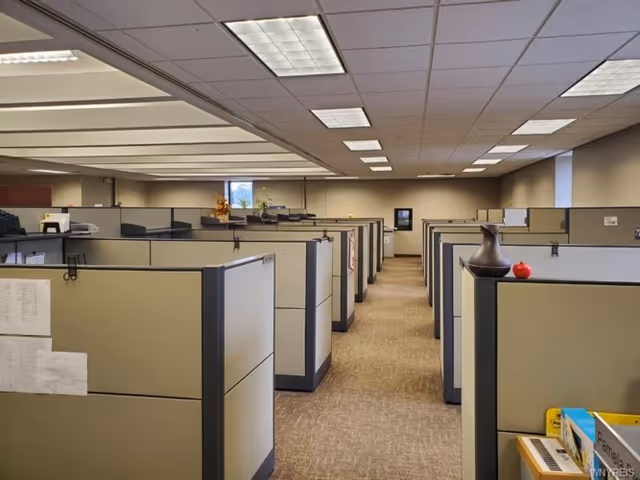 Interior view of a cubicle office area with gray partition walls.