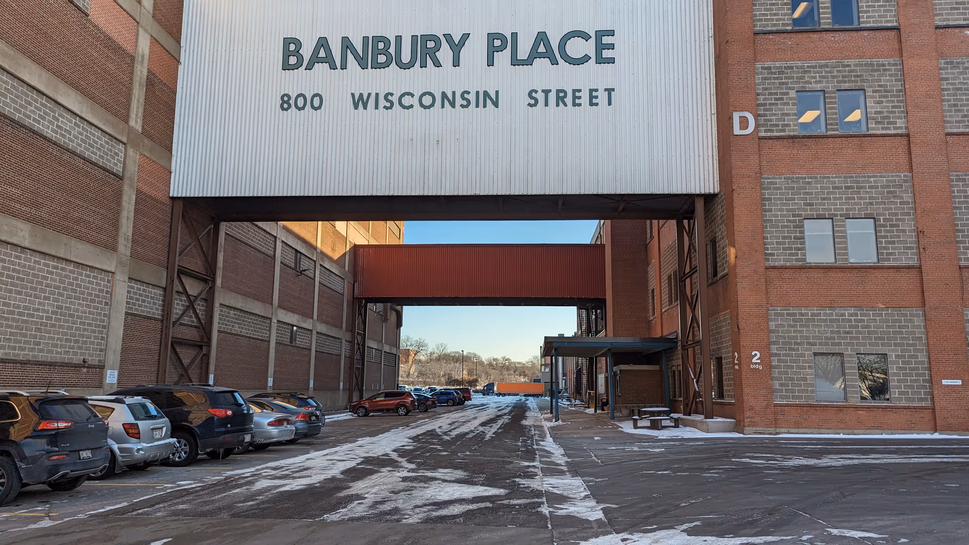 Brick senior housing exterior with Banbury Place sign and snow-covered parking.