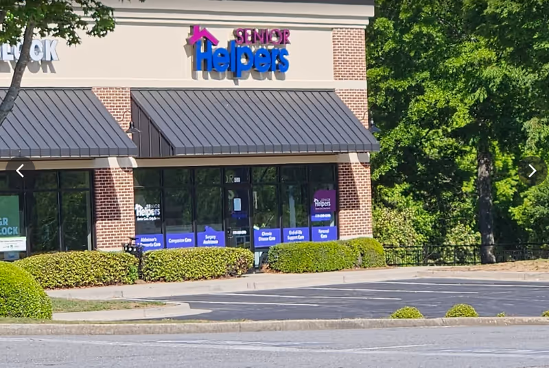 Exterior of Senior Helpers storefront with blue sign and glass windows.