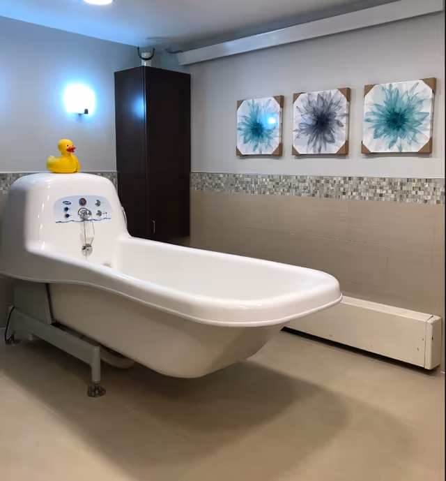 White spa tub in a modern bathroom; rubber duck, abstract wall art.