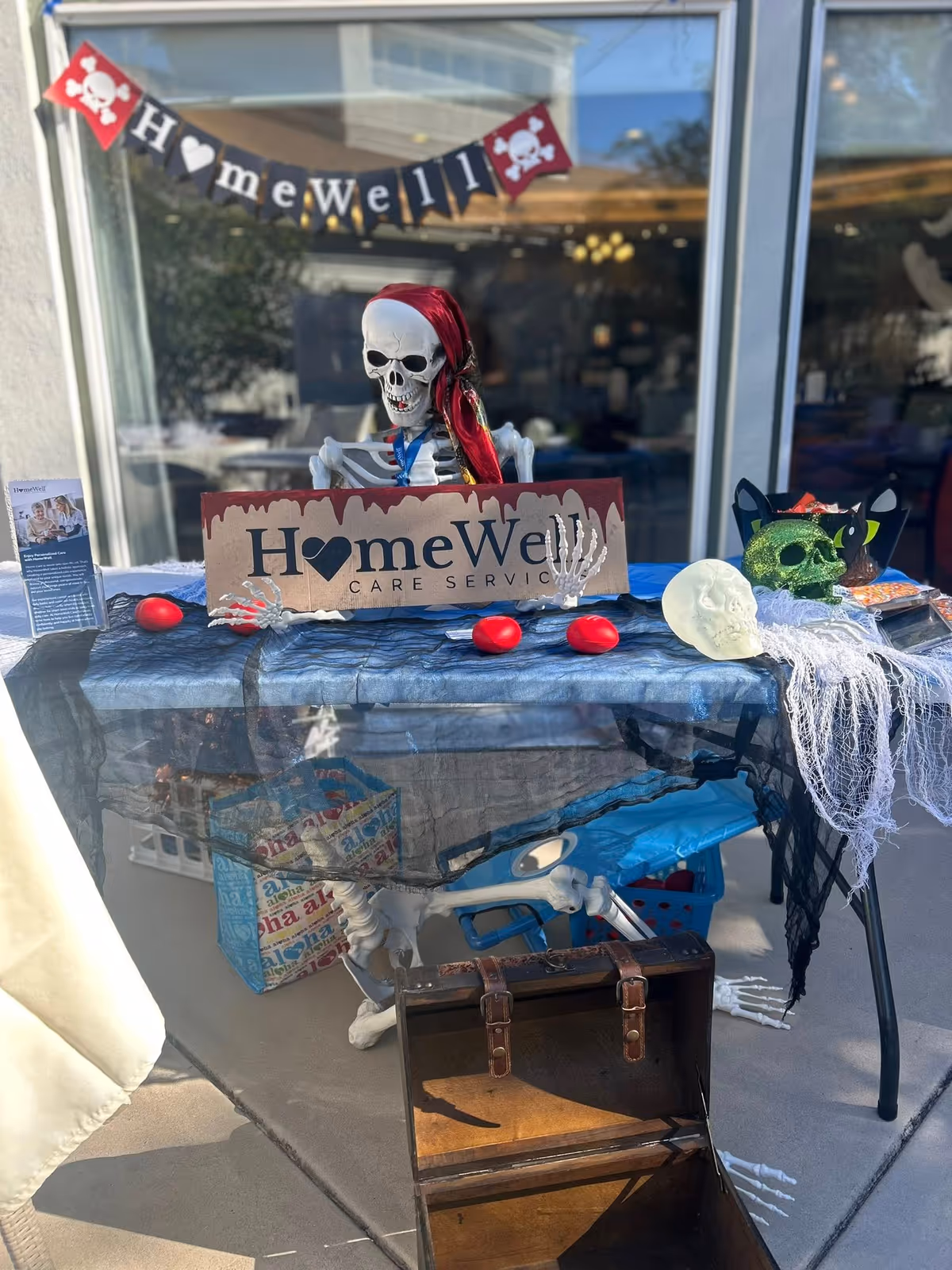 Skeleton Halloween display on a table outside HomeWell Care Services storefront.