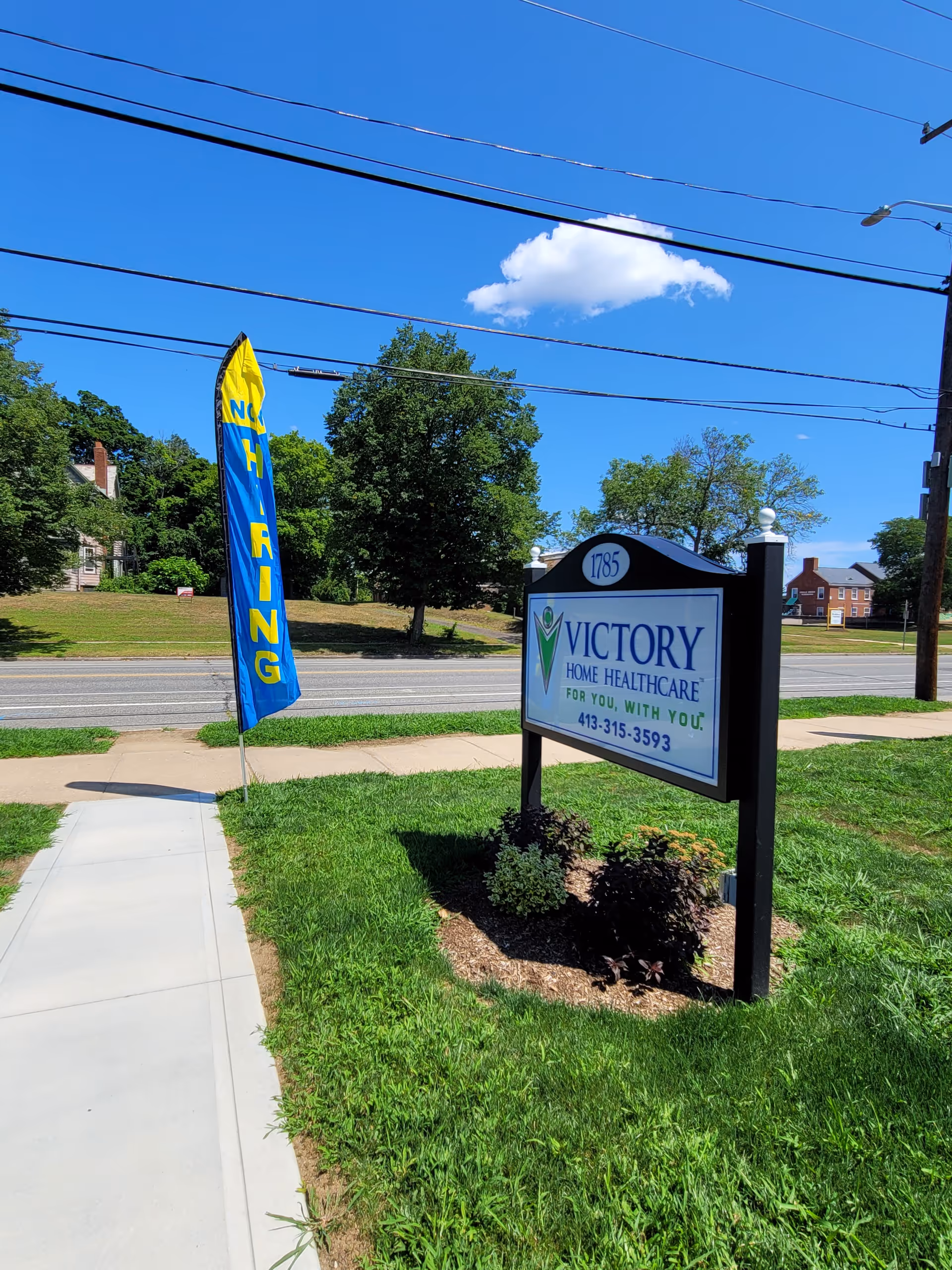 Roadside view of Victory Home Healthcare sign with blue sky and lawn