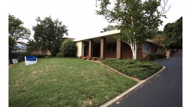 Exterior view of a brick Carilion Clinic Home Care building with a driveway and green lawn