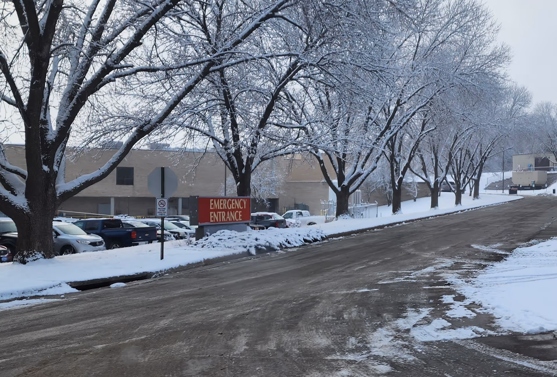 Snowy exterior view of Shenandoah Medical Center with emergency entrance sign along a tree-lined road.
