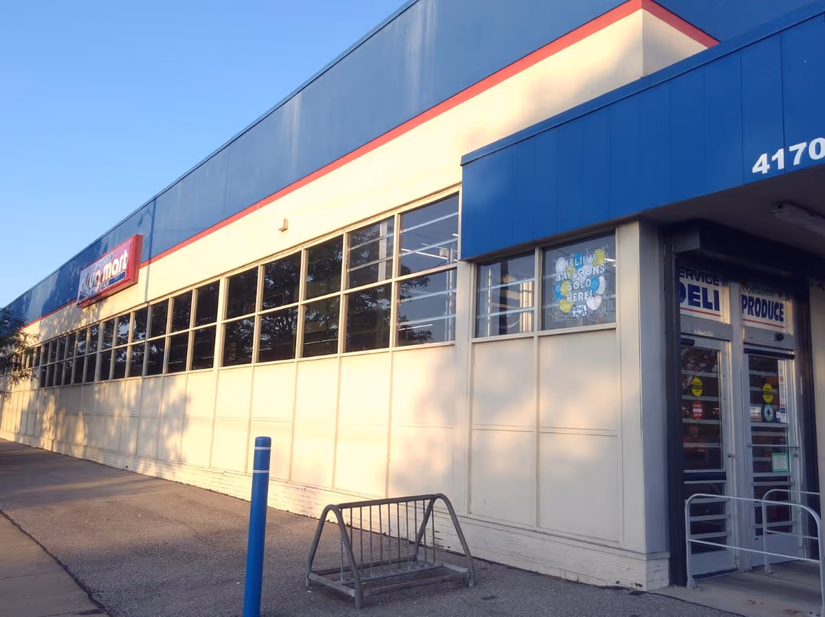 Exterior view of a Discount Drug Mart storefront with large windows and blue accents.