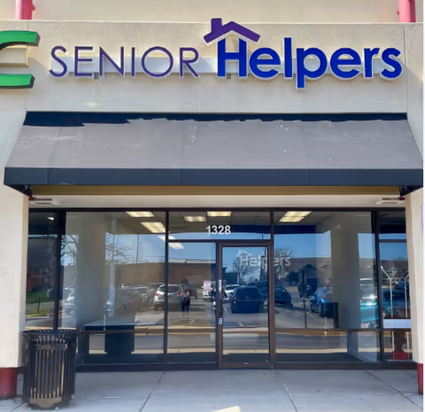 Exterior view of Senior Helpers facility with glass doors and blue awning.