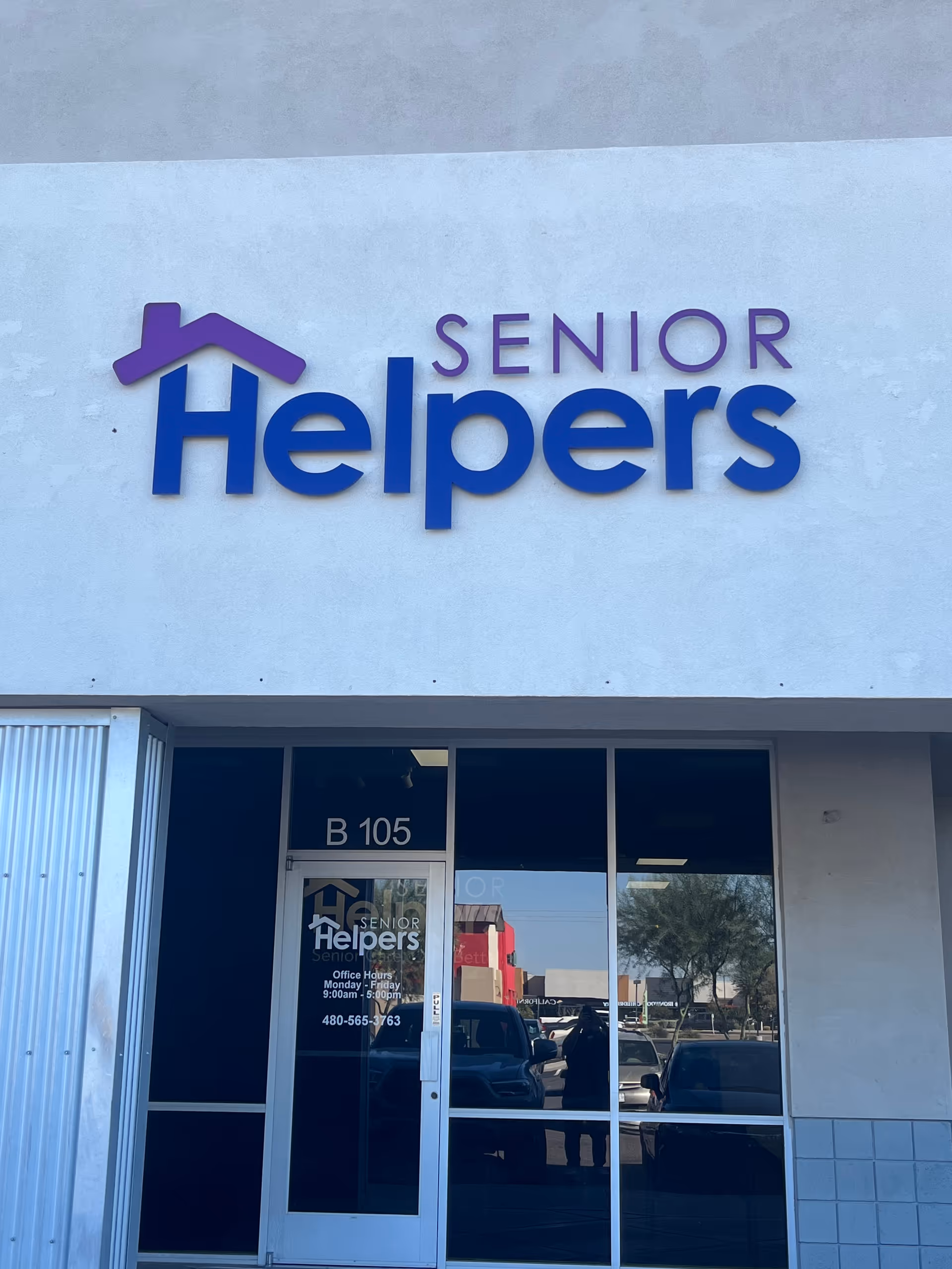 Front exterior of Senior Helpers facility with large blue logo sign above entrance.