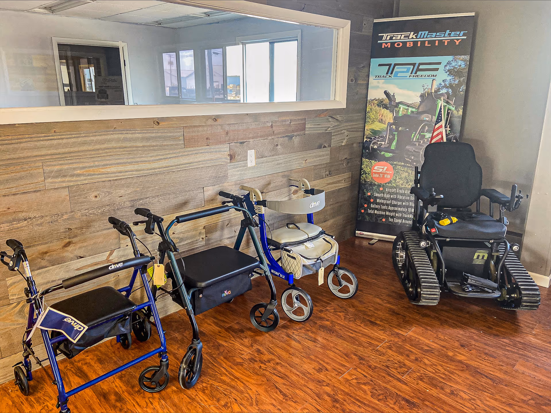 Interior room with multiple walkers and a motorized wheelchair near a wood-paneled wall.