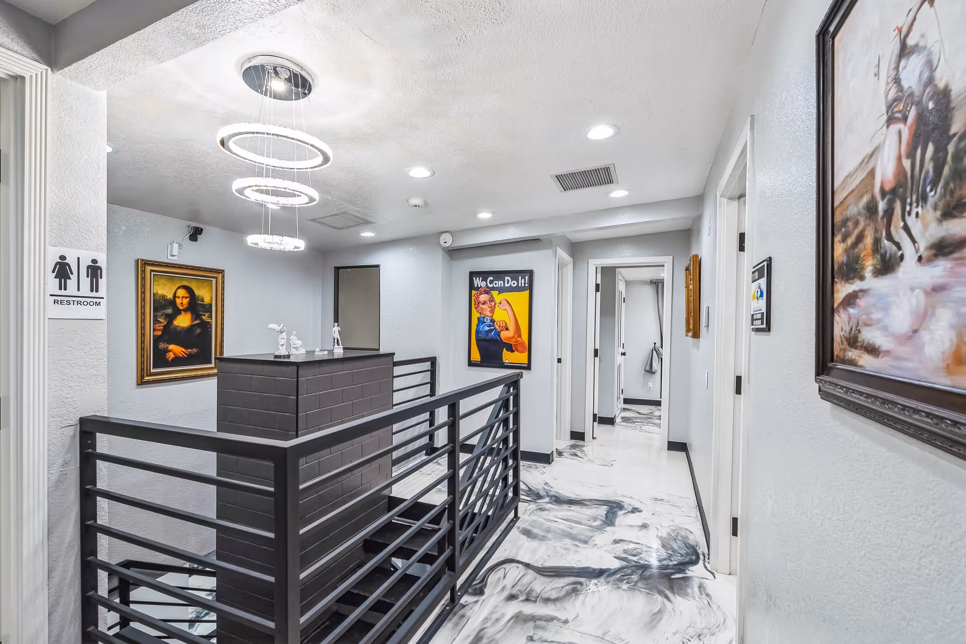 Modern interior hallway of a senior facility with a reception desk, railing, and artwork.