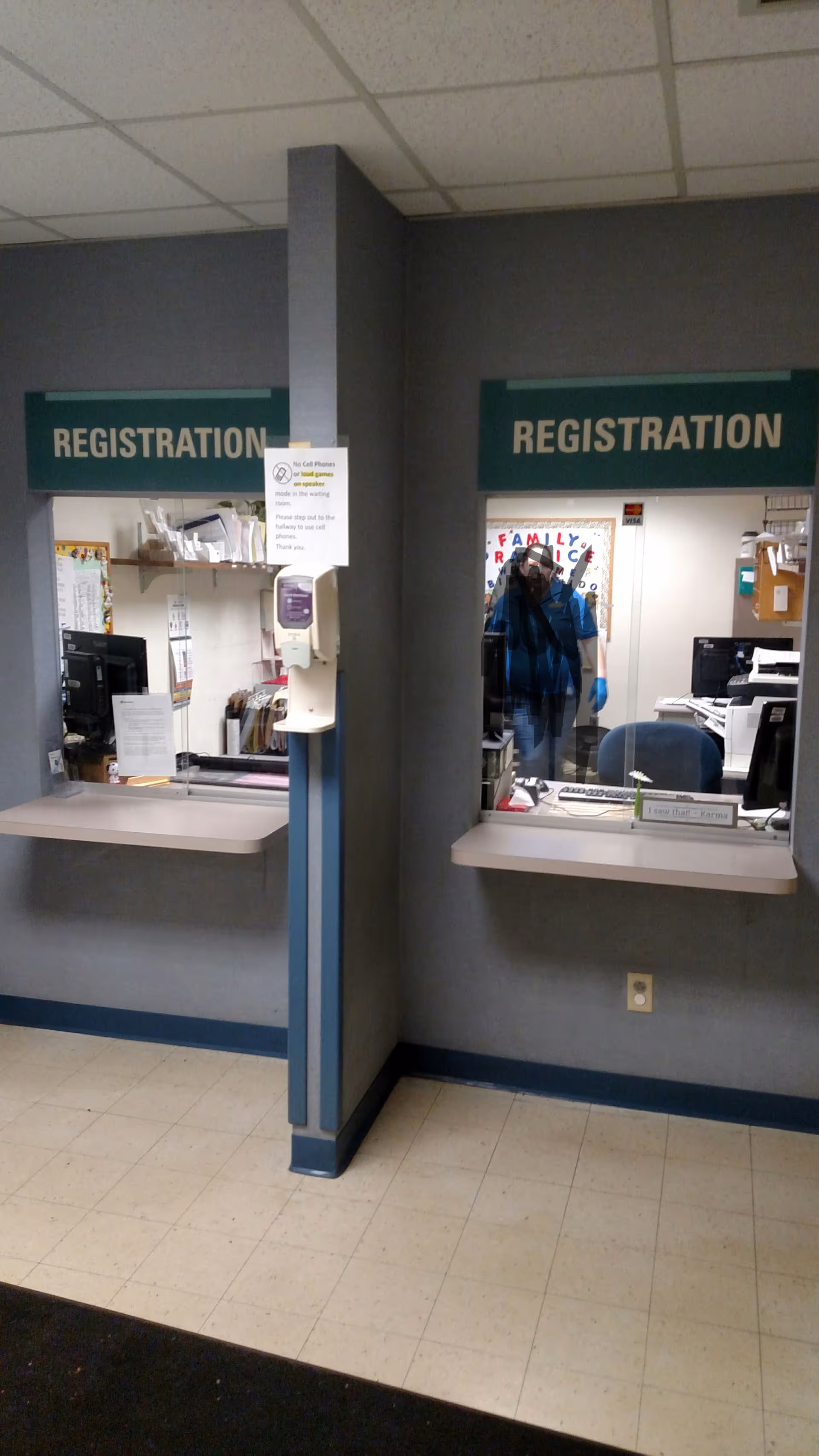 Registration desks with windows and signs in a senior care facility interior.