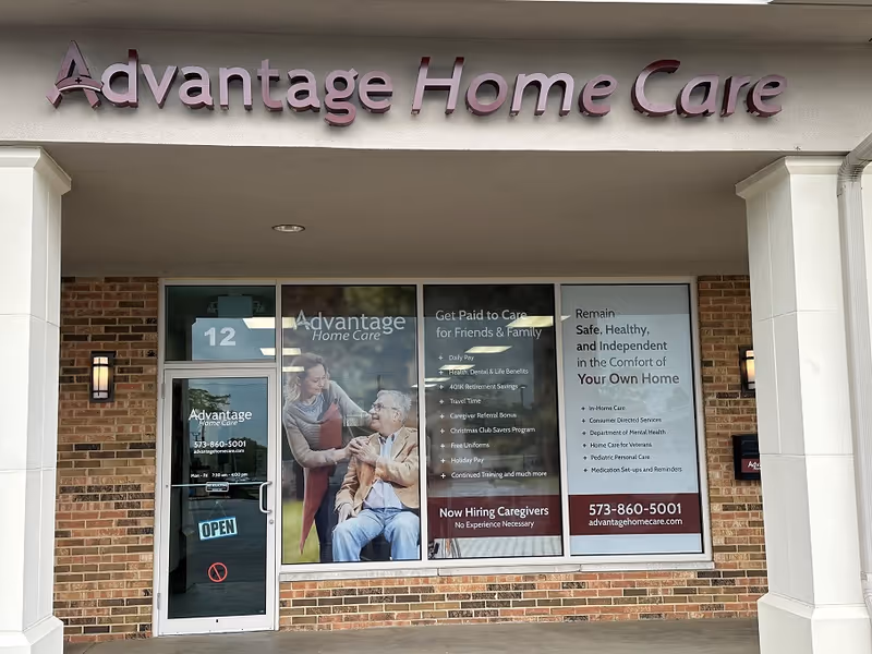 Advantage Home Care storefront with window posters and an OPEN sign