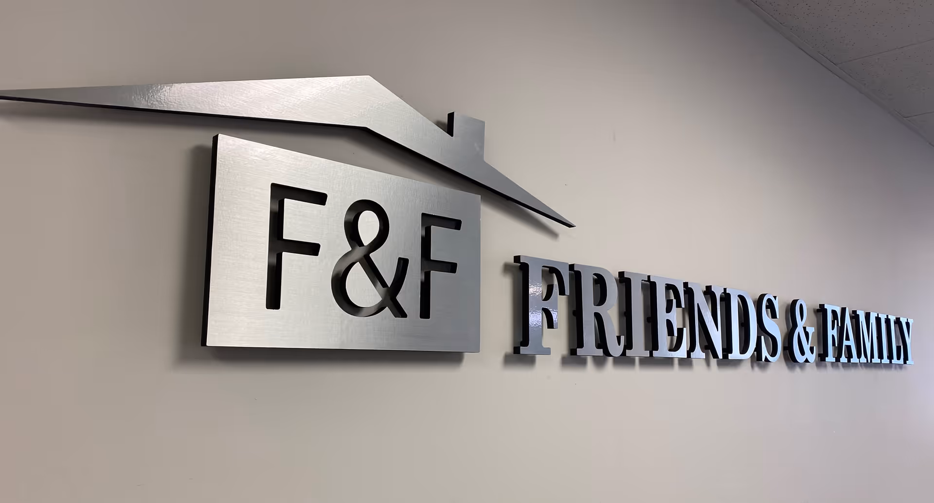 Interior wall sign reading F&F FRIENDS & FAMILY with a roof logo.