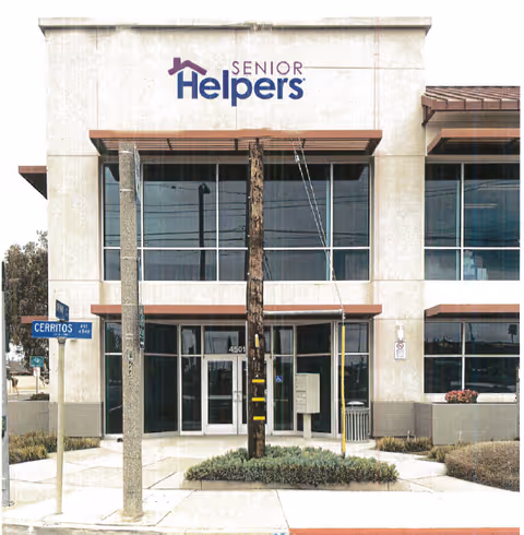 Exterior view of a Senior Helpers facility entrance with large glass doors.