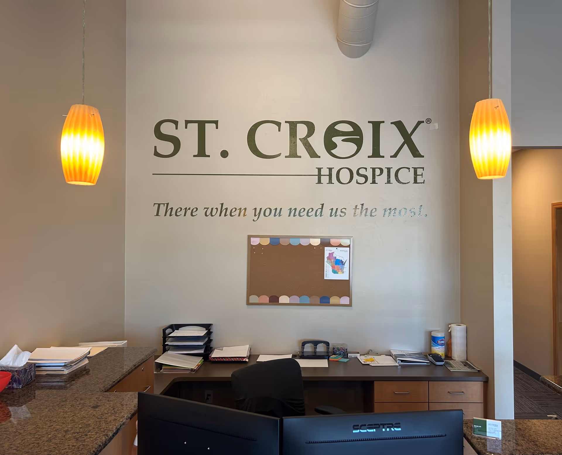 Reception desk in a hospice lobby with St. Croix Hospice branding on the wall.