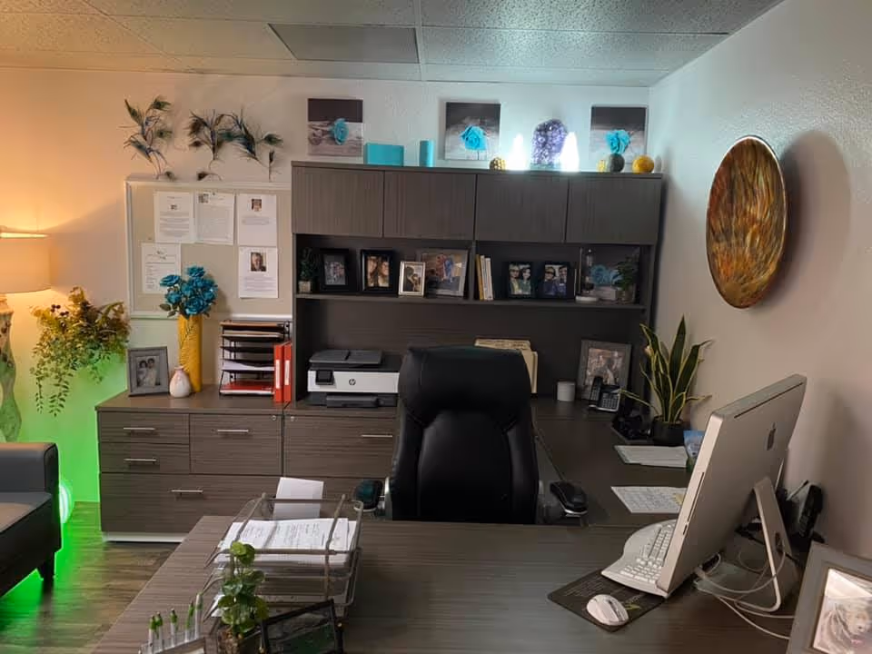 Modern office desk in Miracles Life Care, with computer, printer, and cabinets.