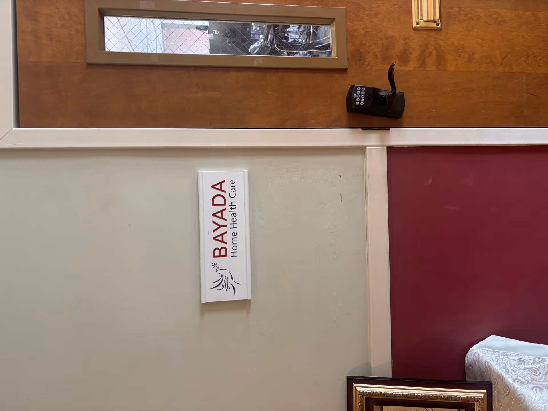 Interior wall featuring a BAYADA Home Health Care sign and wall-mounted phone.