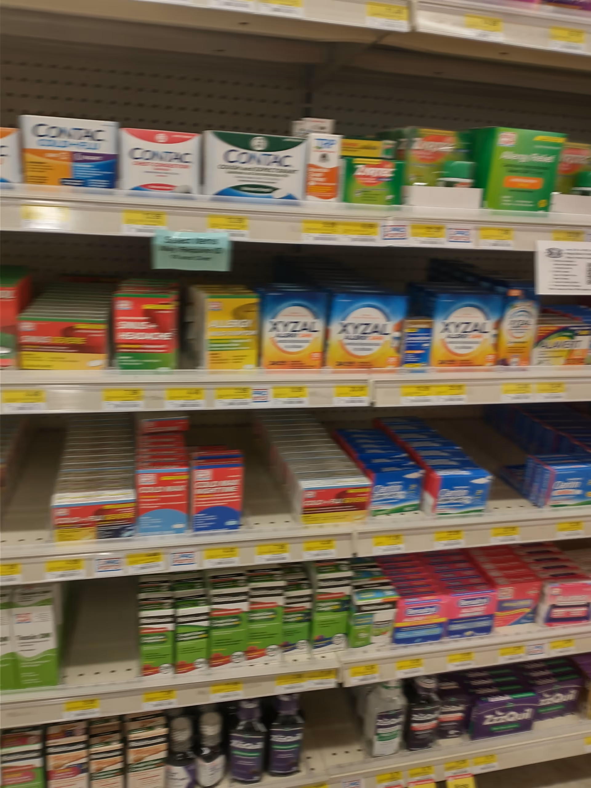 Rows of medicine shelves with boxes and bottles in a Discount Drug Mart store.