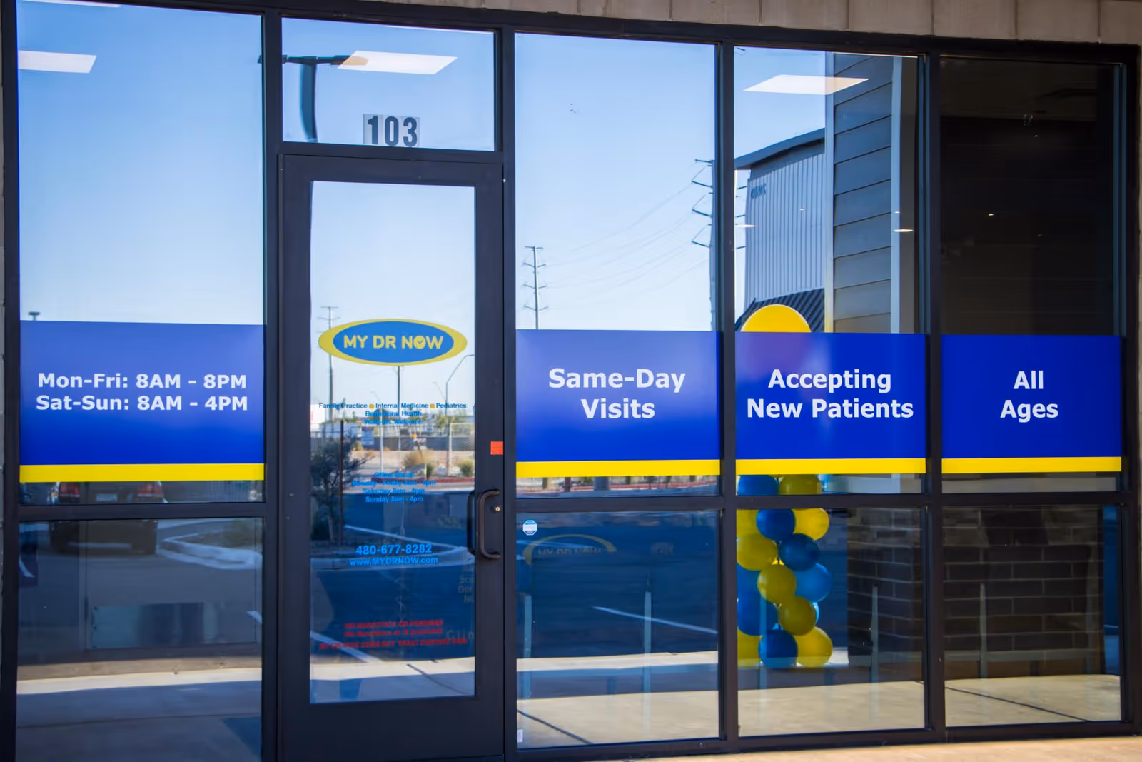 Exterior entrance of MY DR NOW with blue service signs on glass doors