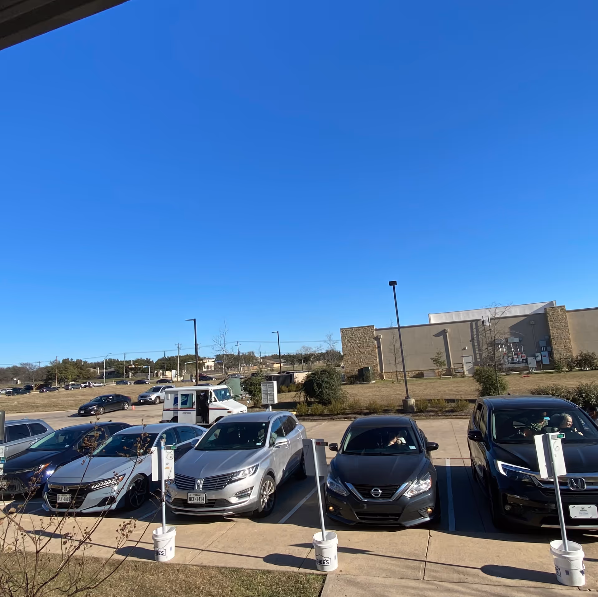 Sunny exterior view of BrightStar Care facility with a row of parked cars.