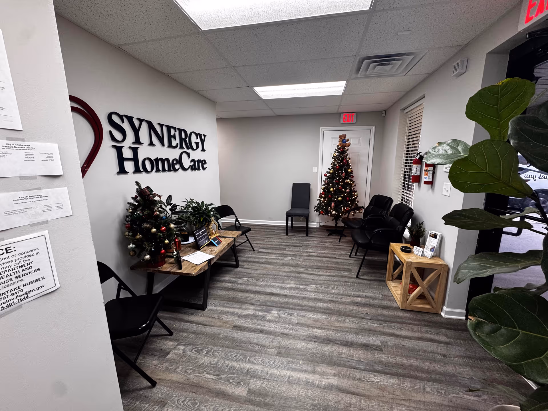 Reception area of SYNERGY HomeCare with chairs, plants, and a Christmas tree.
