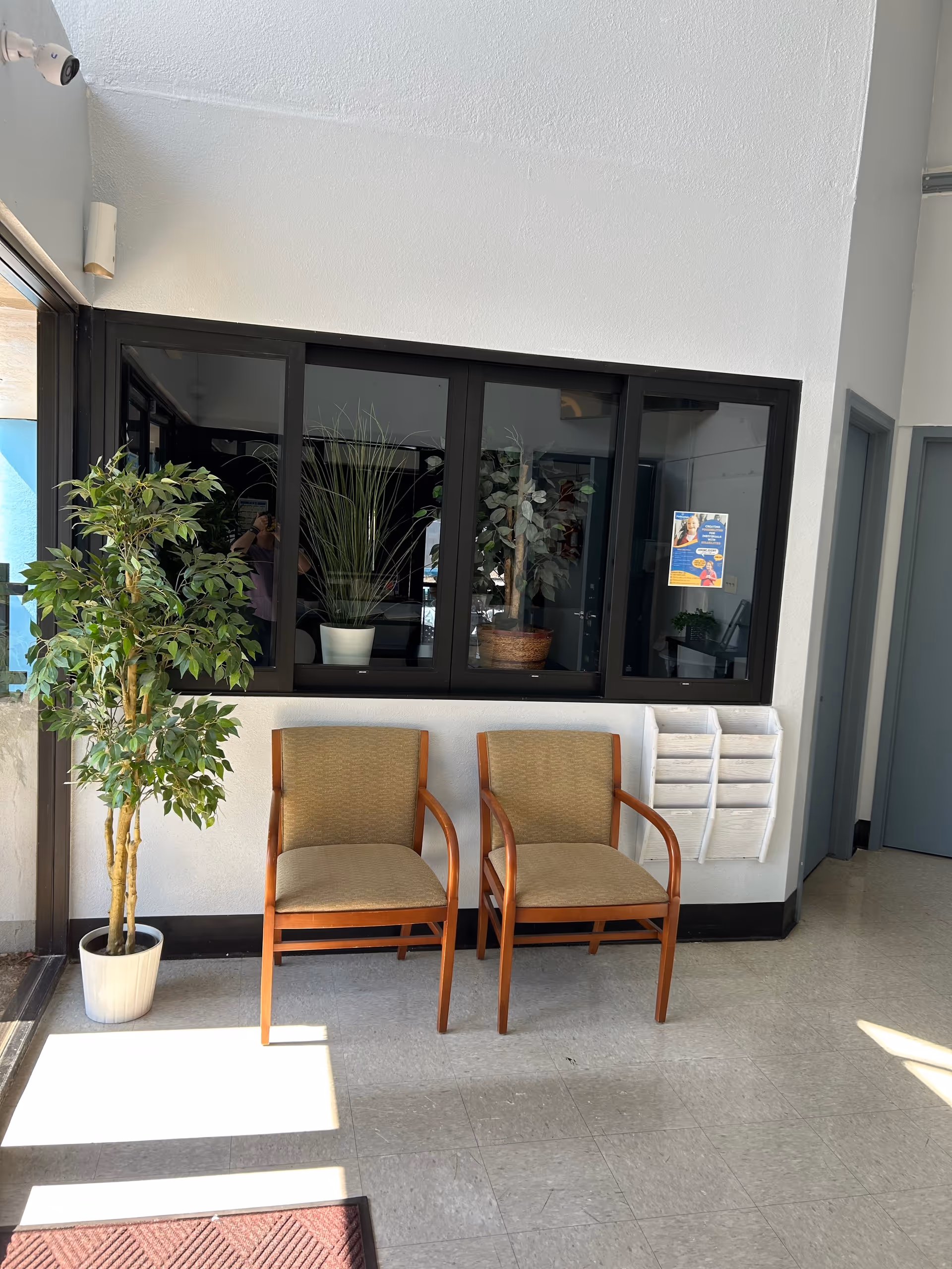 Pathways For Life Mesa lobby with two beige chairs and potted plants.