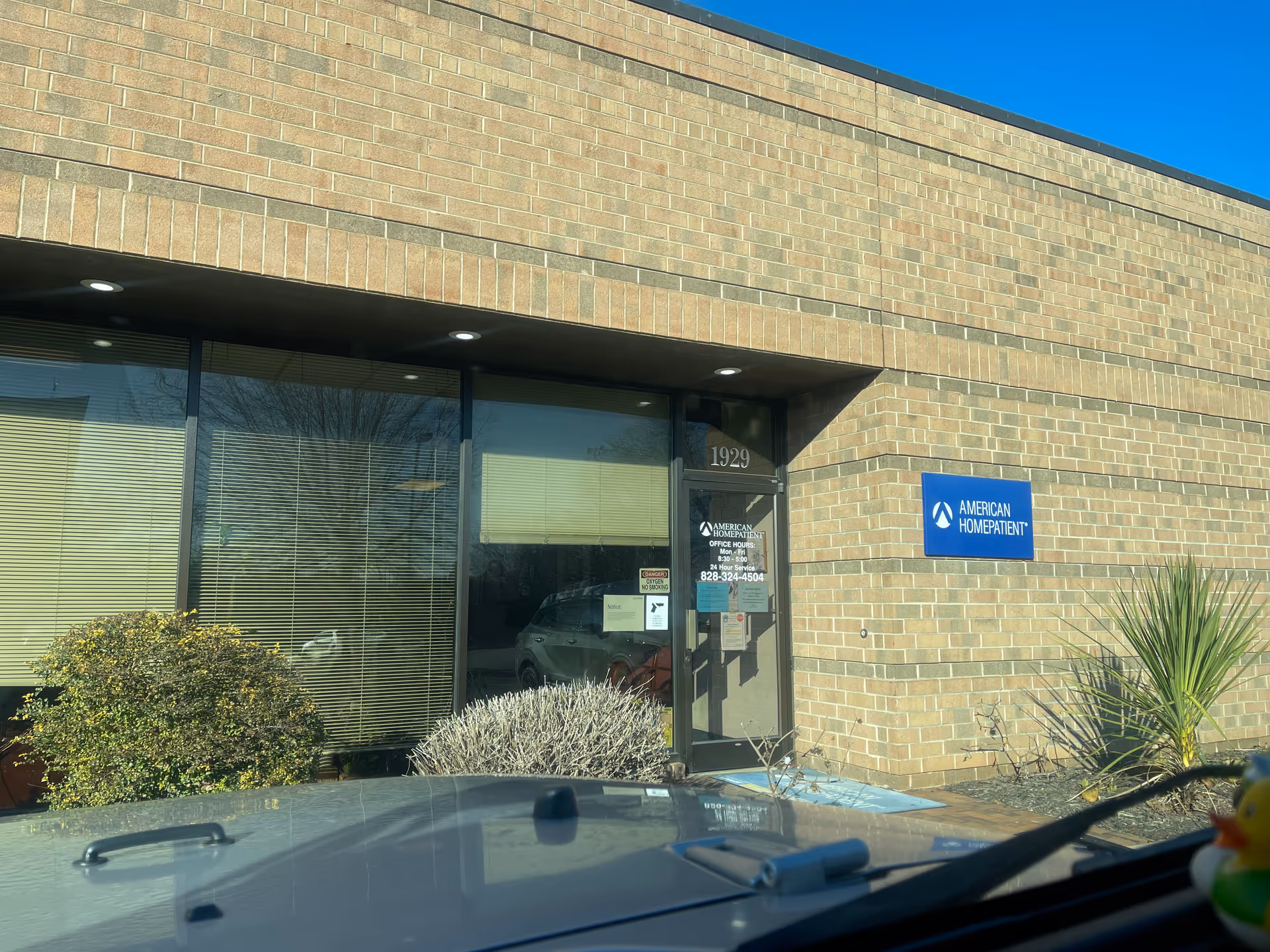 Brick building exterior with glass entrance and blue American HomePatient sign.