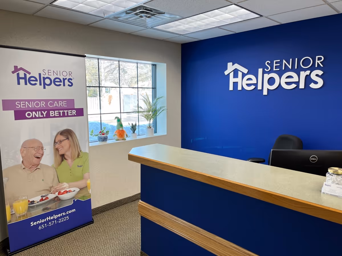 Reception area with Senior Helpers branding on a blue wall and desk.