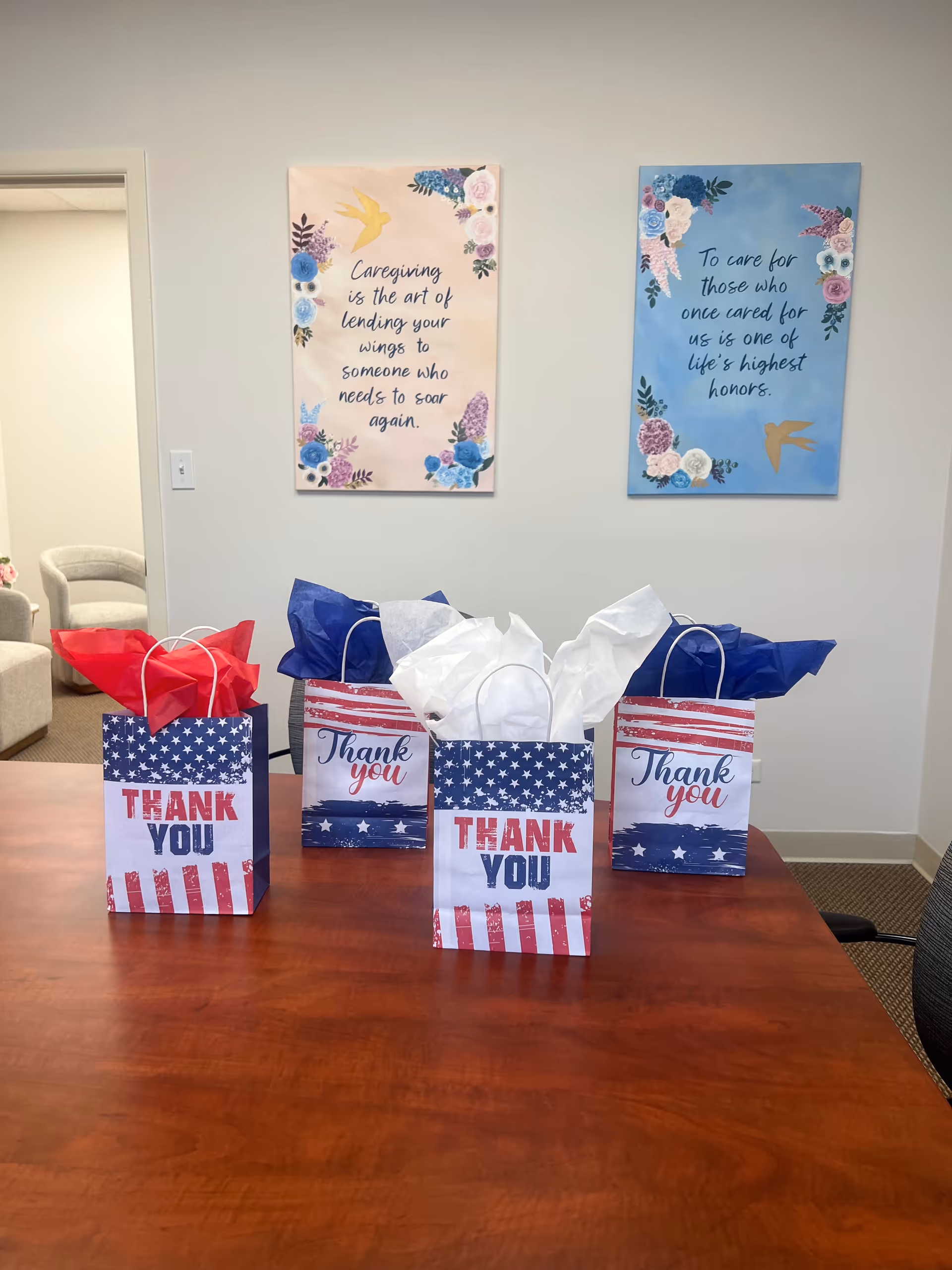 Patriotic gift bags on a wooden table in a senior living facility.