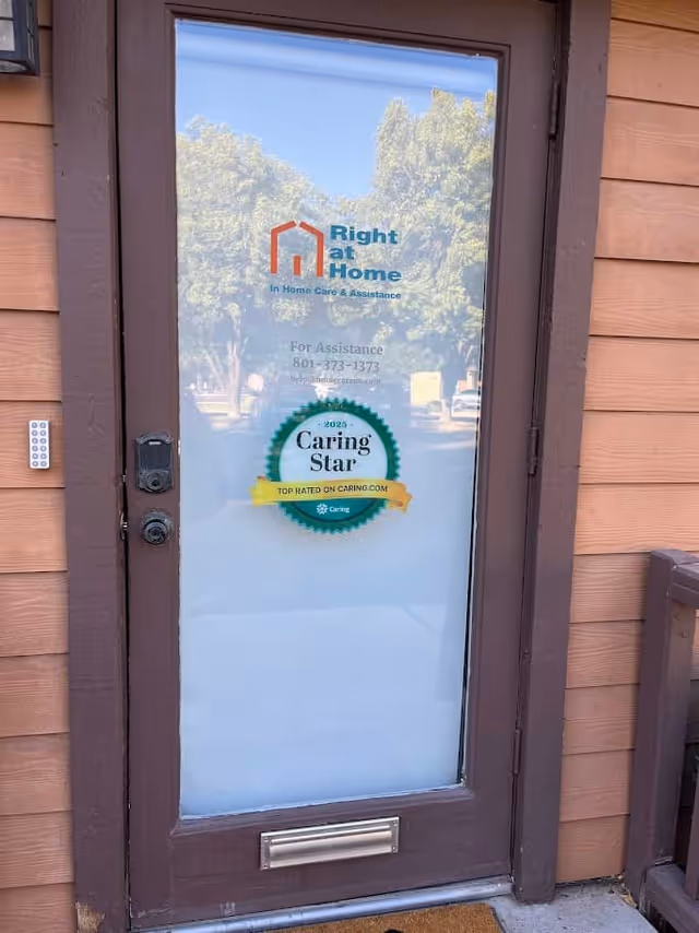 Glass front door with Right at Home logo on a wooden exterior wall.